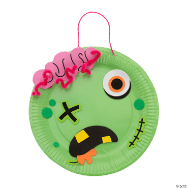 Green paper plate craft with zombie face design on a clear background