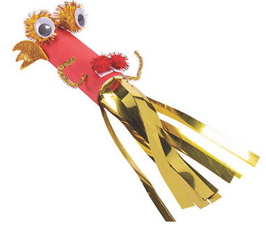 Decorative tassel with gold streamers, red paper tube, and googly eyes on a white background