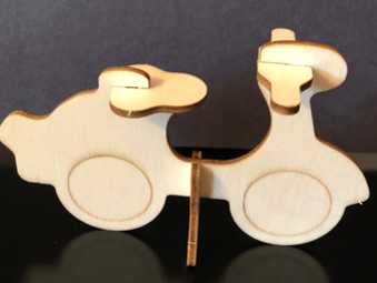 Wooden car model on a reflective black surface
