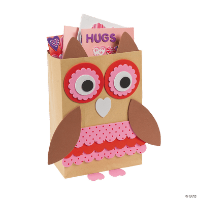 Cardboard owl-shaped box with pink interior holding Valentine's Day cards on a white background