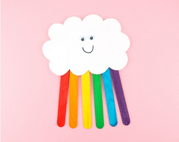 Craft of a cloud with rainbow-colored sticks on a pink background