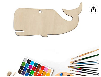 Wooden whale-shaped craft board with paint, brushes, and paint palette on a white background